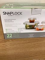 Photo of the sealed original box showing brand Accent Snap Lock Clear by Accent, stating 22 pieces included, features of the lids and containers such as stain and odor resistance, airtight and leakproof seal.