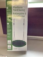 Photo of packaging box showing front view of the platform yard swing with product name and weight limit.