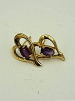Photo of front of earrings showing heart openwork design with oval amethyst stones in each