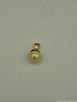 Front view of the 14K gold pearl pendant on white background
