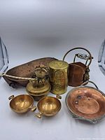 Full view of the seven copper and bronze vintage containers on white background showing the variety of pieces.