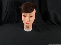 Front view of NP Group mannequin head with brown hair against plain black background