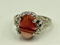 Front view of sterling silver ring showing oval red stone with banding.