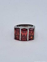 Front view of sterling silver ring with three rectangular red stones showing stone cut and color detail.