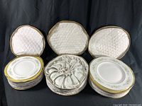 Photo of three open padded cases displaying stacked sets of Wedgwood dinner plates, salad plates, and cups and saucers arranged in a circular pattern in the cup case.