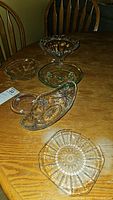 Multiple glass bowls arranged on wooden table showing different shapes and sizes.