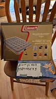 Photo of Coleman Deluxe Quickbed full-size airbed box and separate pump box with handwritten label.
