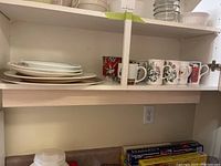 Mugs, Corelle plate, bowl, and serving platters arranged on a shelf
