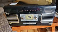 Front view of vintage TEAC SL-A100 stereo turntable showing speaker grills, 'STEREO' branding, and central radio tuner dial with knobs.