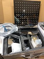 Complete shower faucet set components placed inside custom foam packaging in box
