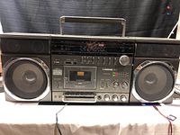 Front view of entire Lasonic LPC-82 portable stereo with speakers, cassette deck, control buttons, and carrying handle.
