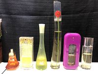 All six perfume bottles displayed in a row on black background showing different shapes and colors.