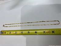 Full view of necklace on white background with measuring tape