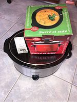 Photo showing Betty Crocker mini crock pot box placed on top of the Crock-Pot slow cooker appliance, visible packaging and product info.