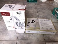 Packaging of Pfister Masey faucet and Allen + Roth faucet showing brand logos, images of faucets, and product details.