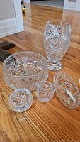 Overview of five crystal pieces showing the pinwheel cut designs, including the vase, large bowl, smaller bowl, creamer, and round dish.