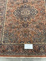 Close-up photo of the area rug showing its detailed pattern and color scheme including central medallion and border design.