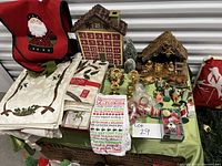 Photo showing advent calendar, nativity scene, assorted table linens, and candle holders on green cloth