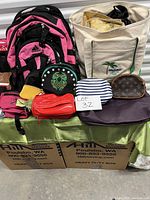 Full lot view showing a variety of bags including Adidas backpack, reusable tote bag, makeup and change bags.