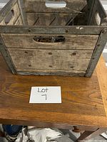Wooden milk crate showing slatted wood panels and metal corner reinforcements