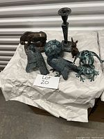 Overall view of metal decorative items including animal figurines, a candlestick holder, and a spherical candle.