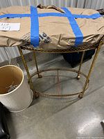 Photo showing bar cart with glass inserts and a lamp shade next to it