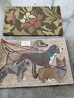 Two accent rugs stacked, top shows floral design, bottom shows dog design.