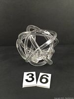 Front view of the clear blown glass knot sculpture.