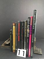 Front view of the 10 books arranged upright supported by bookends, showing their spines with titles.