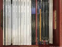Photo of various Sotheby's and Bonhams jewelry auction catalogs lined up vertically showing titles and auction locations, dates.