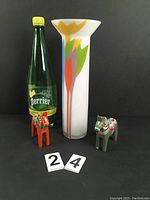 Front view of MCM vase and two small horses alongside a Perrier bottle for scale.