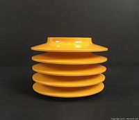 Stacked view of the five yellow plates showing shape and color