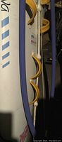 Close-up of yellow foot straps on white and blue windsurfing board surface