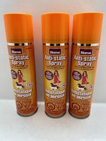 Front view of three orange-capped cans of Home Anti-static Spray showing label and branding.