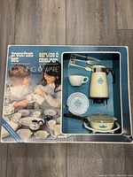 Photo of original box showing the set contents and packaging with children playing image and partial toy items visible.