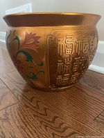 Full side view showing gold planter with Asian characters and floral artwork.