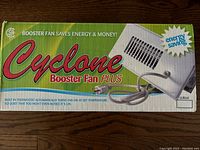 Photo of the Cyclone Booster Fan Plus product box showing brand and product name along with features such as energy saving and thermostat control.