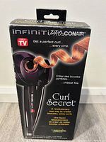 Original box of Infiniti Pro by Conair Curl Secret hair curler showing front view and product branding.