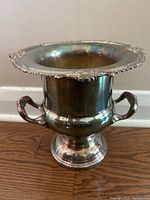 Front view of silver plated ice bucket showing decorative rim and handles