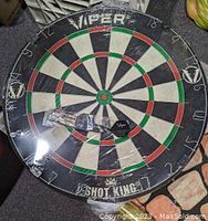 Photo shows Viper Shot King dartboard wrapped in plastic with Viper branded darts still in plastic placed on top.