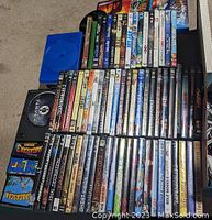 Photo showing a mixed lot of DVDs and Blu-ray discs stacked together, with visible titles across various genres and a count of about 40 discs.