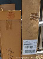 Photo of two cardboard boxes presumably containing space saver bags, one labeled 'Space Saver Bags' with handwriting, the other with a QVC shipping label.