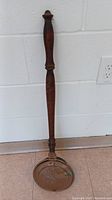 Full view of the antique bed warmer with long turned wooden handle and closed copper pan base.