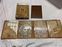 The Elder Scrolls IV: Oblivion Special Edition Xbox 360 game with box, two discs (game and bonus materials), and map-themed packaging.