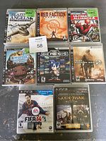 Eight PlayStation 3 game cases laid out showing cover artwork and titles: Blazing Angels Squadrons of WWII, Red Faction Guerrilla, Command & Conquer Red Alert 3 Uprising, LittleBigPlanet, Sonic's Ultimate Genesis Collection, Call of Duty: Modern Warfare 2, FIFA 14, God of War Collection.