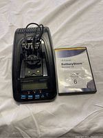 Photo of Cadex Battery Tester and BatteryStore installation CD on fabric background.