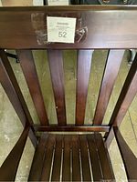 Close-up of the chair's backrest showing the vertical slat design with scratches and dings.
