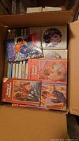 Open box showing the top view of several Harlequin Romance paperback books with visible cover art and titles.