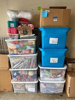 Stack of clear drawer units and blue plastic tote bins filled with yarn and craft supplies
