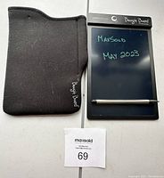 Boogie Board tablet displaying handwritten text 'MaxSold May 2023' with stylus pen attached and black protective soft case beside it.